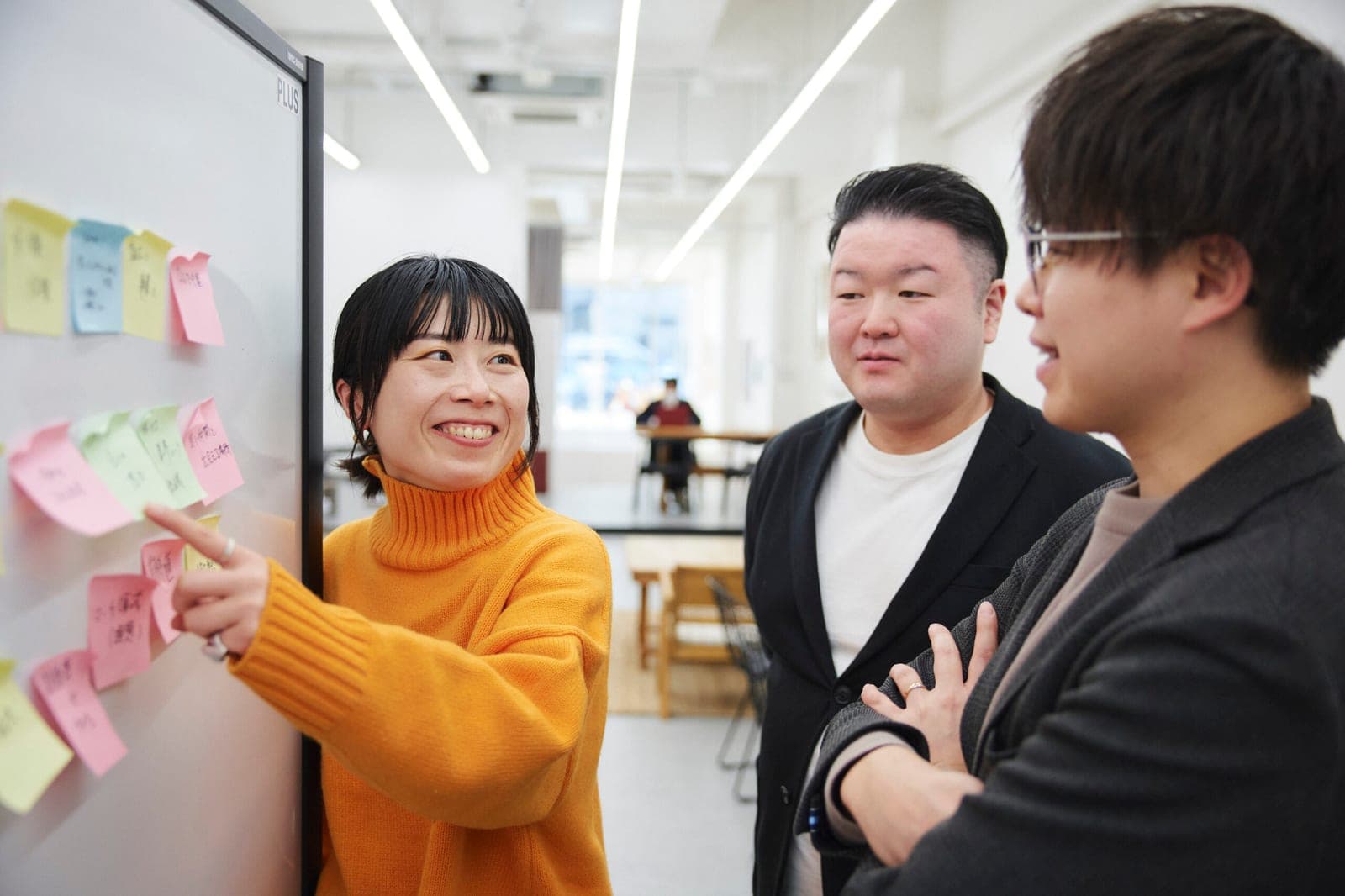 ホワイトボードに貼った付箋を前に打ち合わせをする株式会社NOVELのメンバー