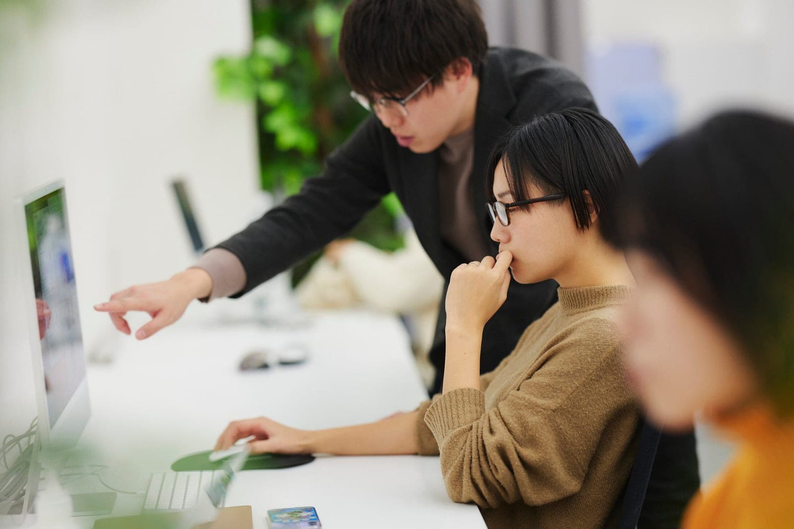 オフィスでモニターを見ながら業務内容を確認する株式会社NOVELのメンバー